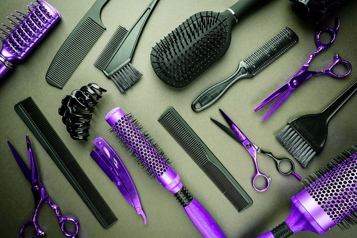 平面背景上的沙龙工具，梳子，刷子，剪刀，卷发棒.